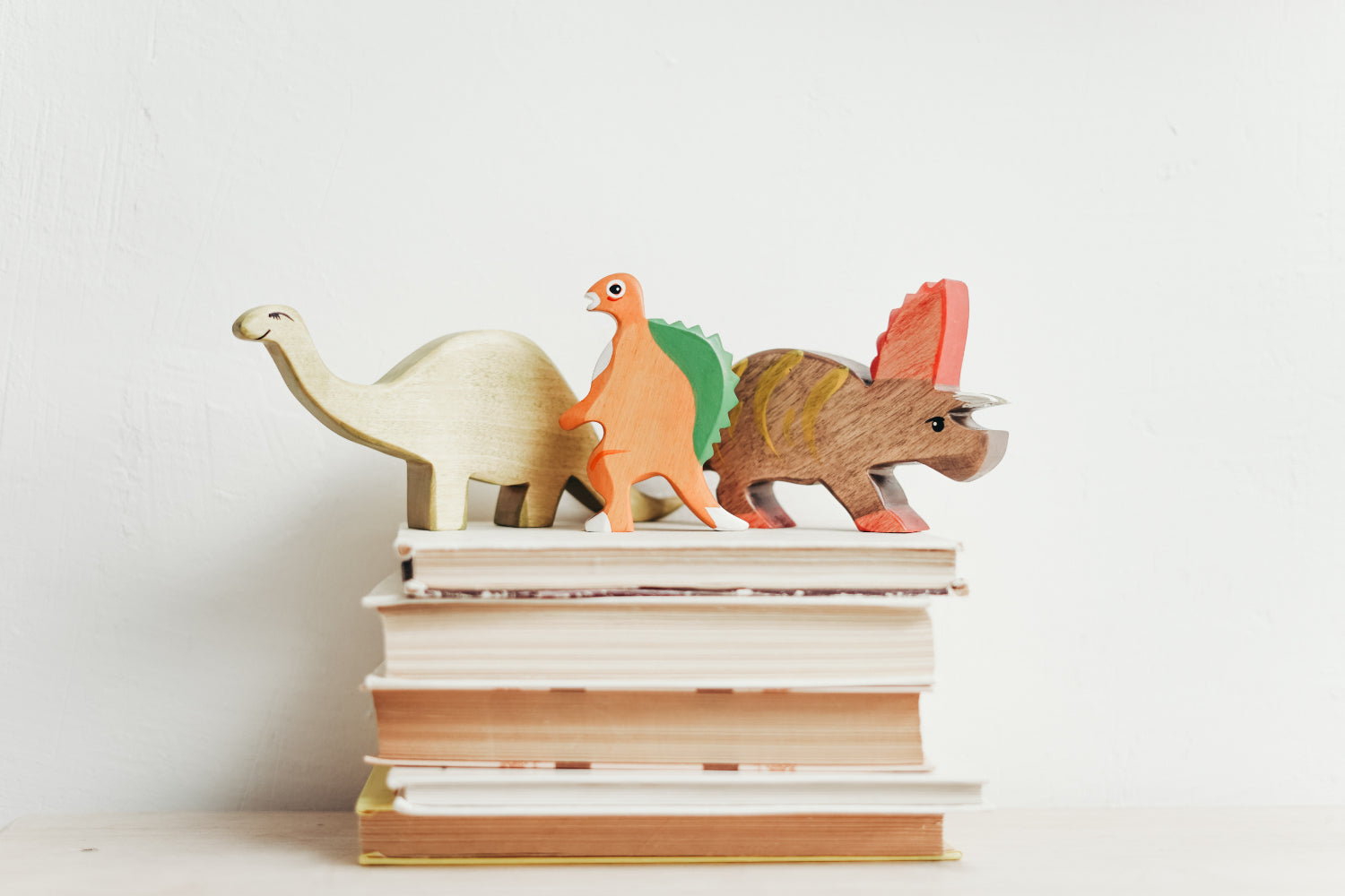 Stack of books topped with dinosaur toys