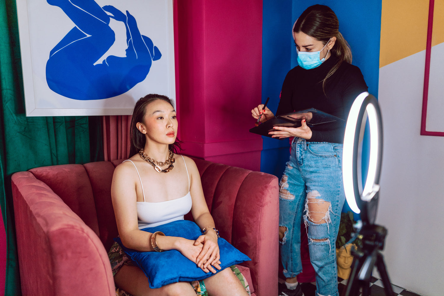 A makeup artist preps a model for a shot