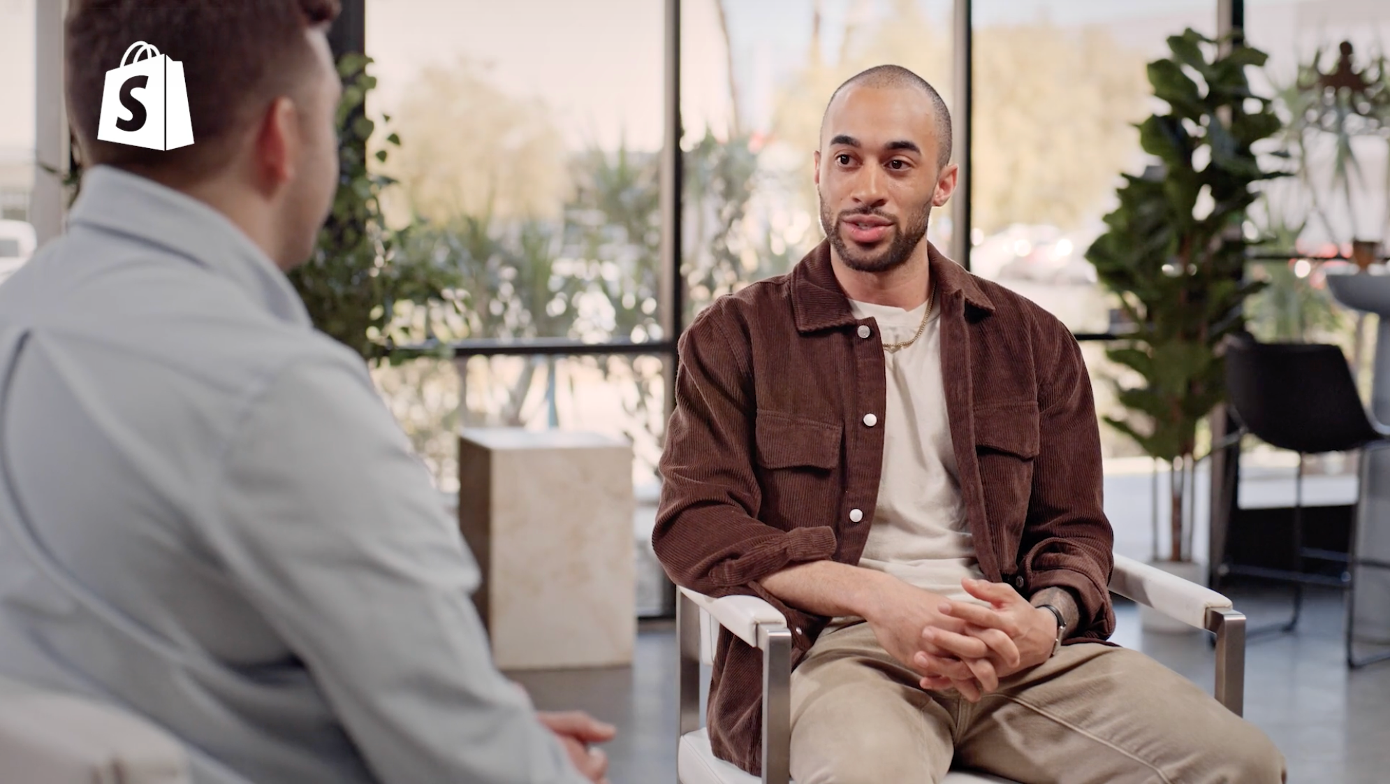 Jahmal Gittens sits for an interview wearing a brown shirt jacket and cream t-shirt.