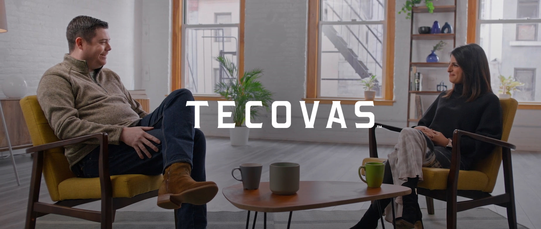 Image of a man sitting next to a woman being interviewed in the background with the logo of Tecovas over the image.