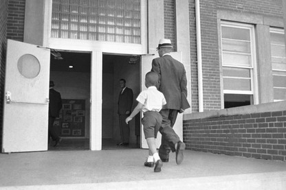 A man and his son walking into a school