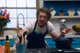 The actor Jeremy Allen White leaning over a kitchen counter and talking to the camera.