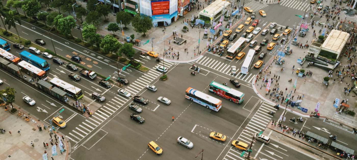 A busy road intersection with vehicles and transport buses.