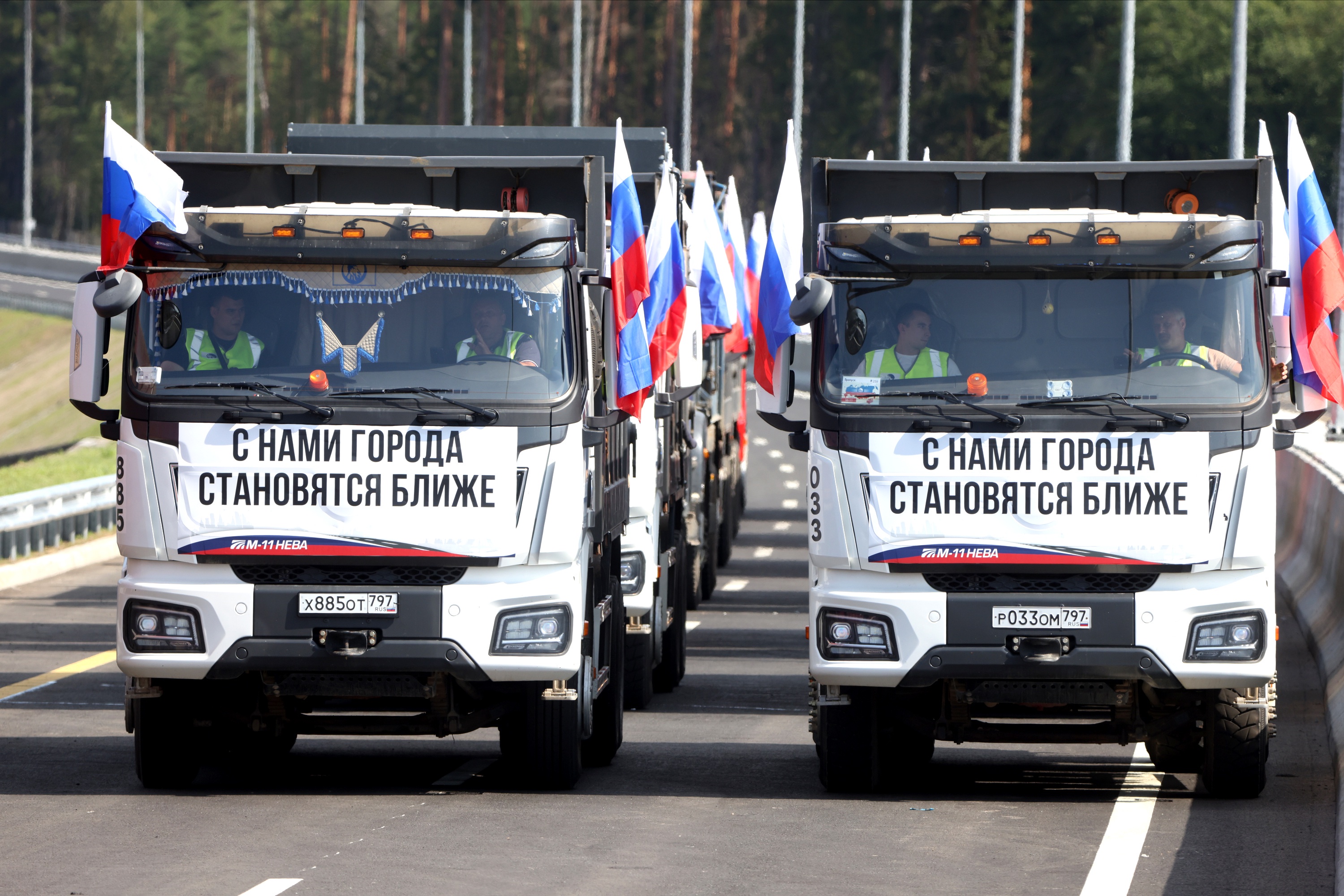 Колонны автотранспорта с плакатами поехали по новой дороге.