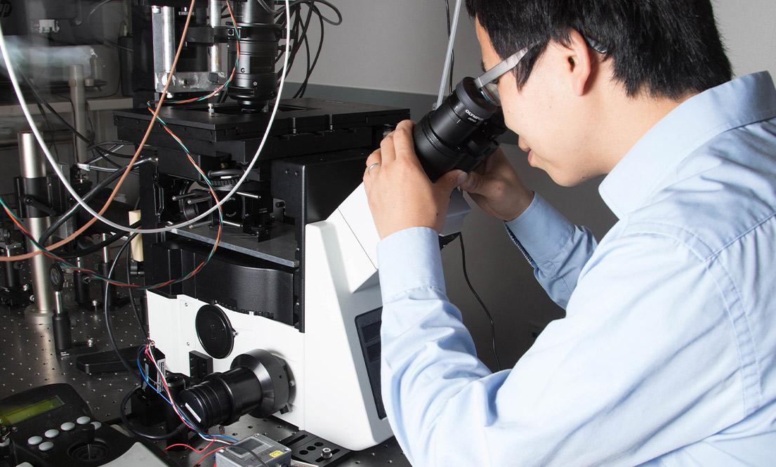 student looking through a microscope