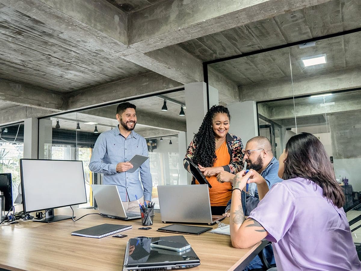 four coworkers in conference room meeting