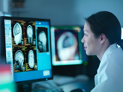 Scientist looking at 3D rendered graphic scans from Magnetic Resonance Imaging (MRI) scanner, close up