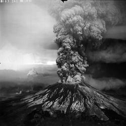 Volcano erupting and spewing a huge cloud of rock and ash into the sky.