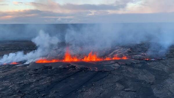 Lave erupting from a fissure as seen from a helicopter flover.