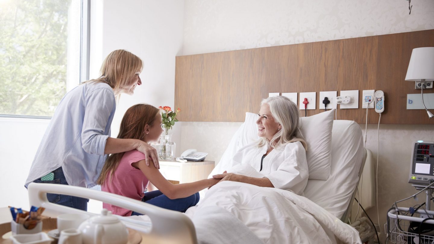 Granddaughter Talking With Grandmother On Family Hospital Visit