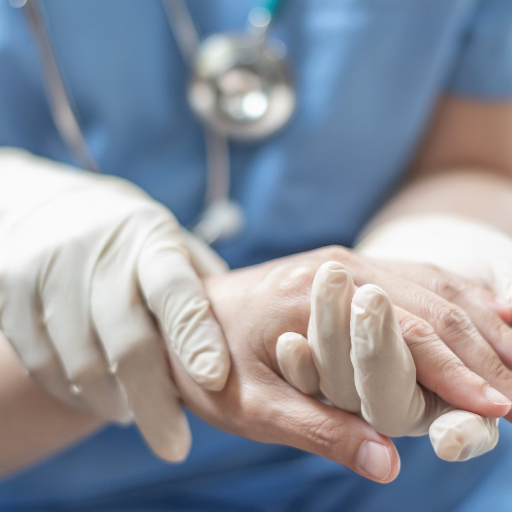 Surgeon, surgical doctor, anesthetist or anesthesiologist holding patient's hand for health care trust and support in professional surgical operation, medical anesthetic safety, healthcare concept