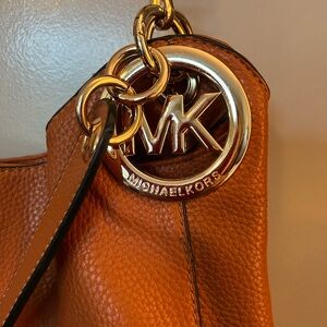 This is a vegan leather Michael Kors style bag & will hold Everything!