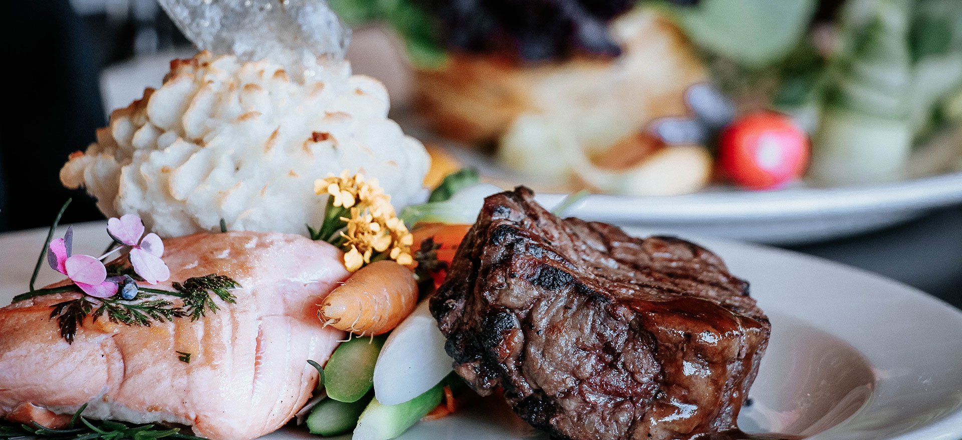 Catering meal with artisan-decorated fillet-mignon, salmon and vegetables.