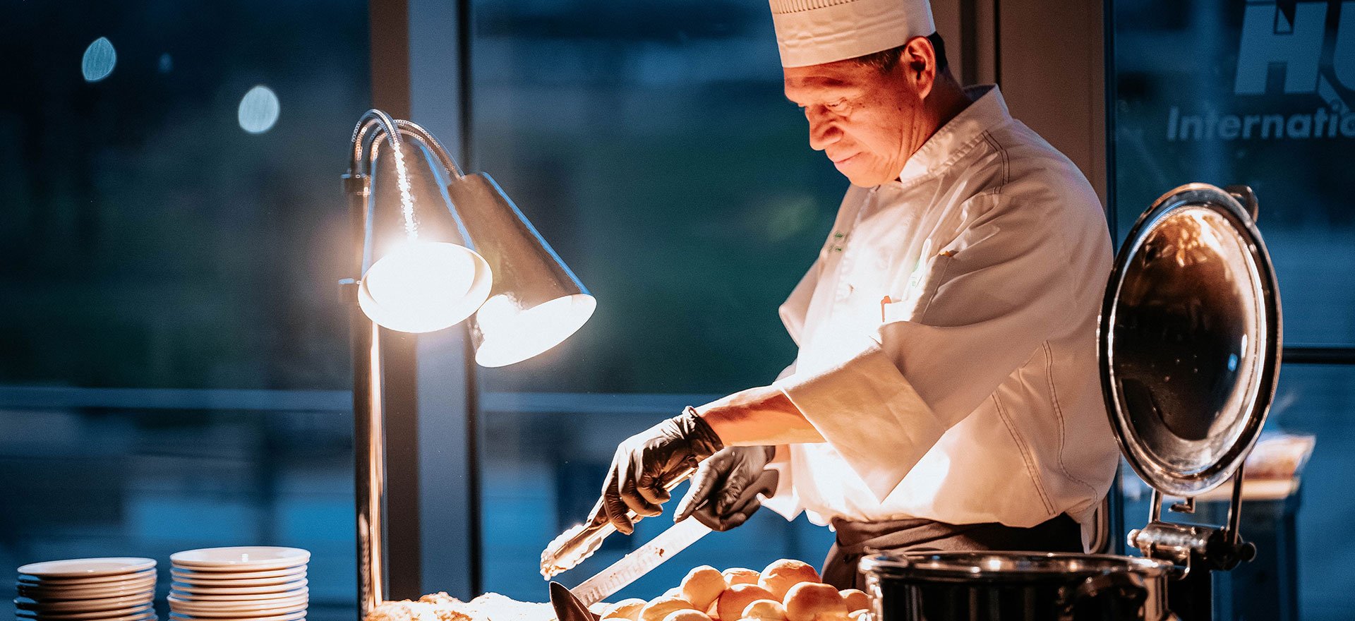 Artisan chef carves meat at a catering event