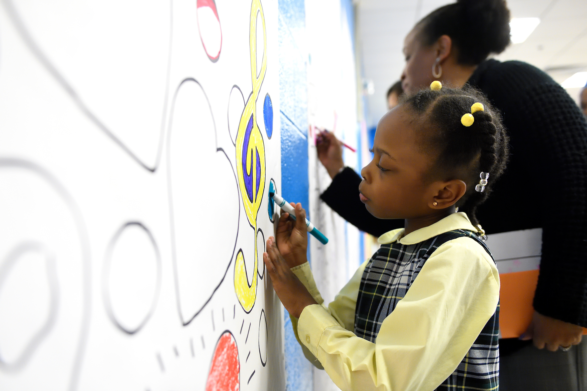 A child drawing on a whiteboard with a marker.