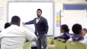 A person standing and teaching in a classroom.