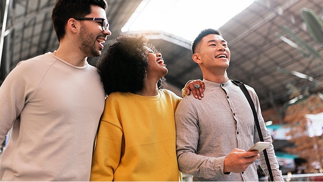 Group of friends laughing and walking closely in open airy space