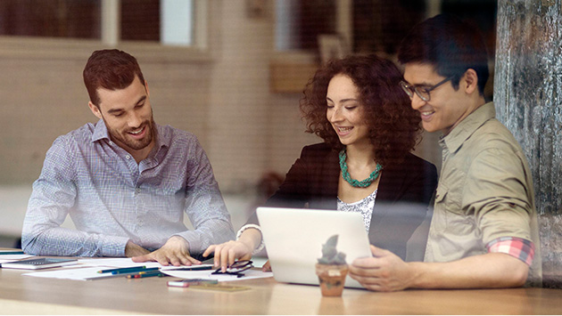 Group of people looking at colleague's work