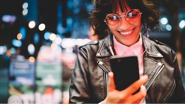 Hip woman in the city looking at her phone