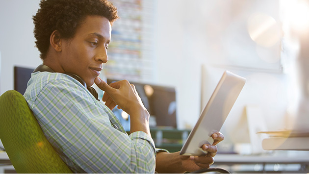 Pensive man looking at tablet in profile view