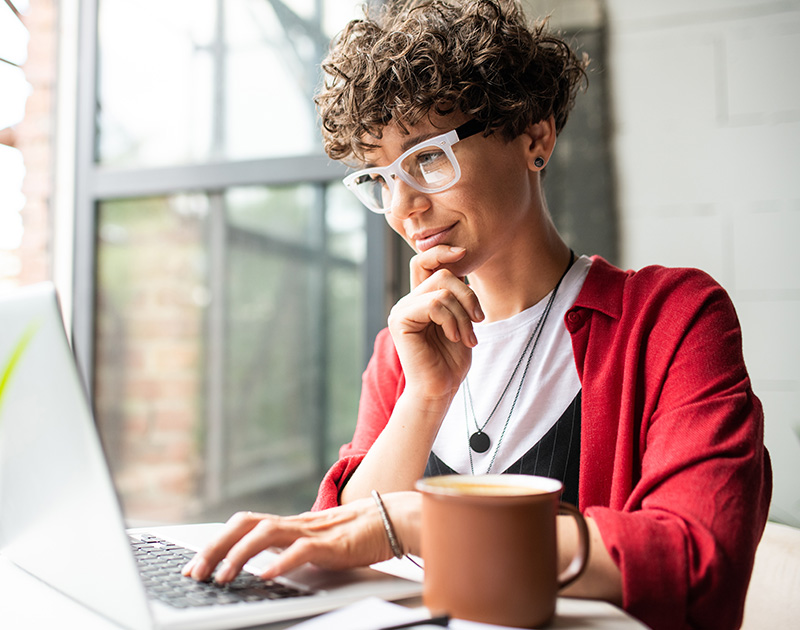 Woman thinking while looking at laptop