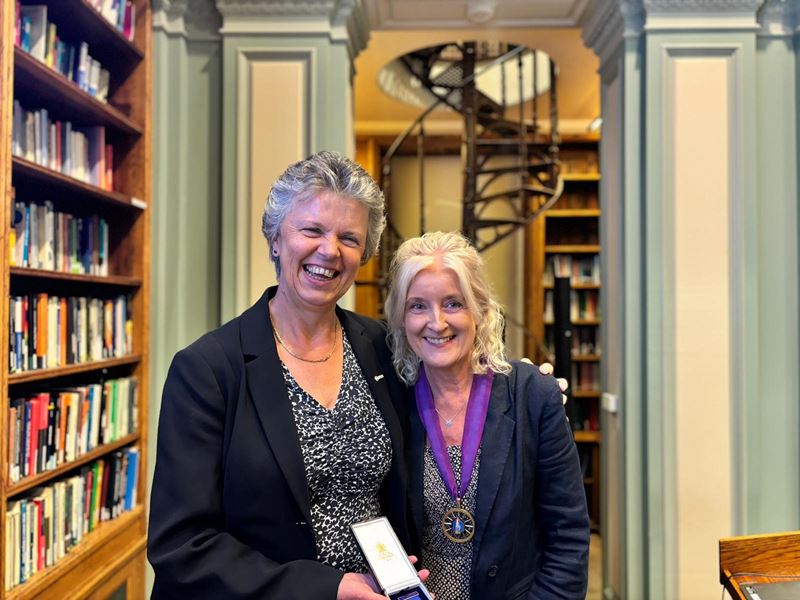 Professor Gill Reid and Dr Annette Doherty stand in the Library Room at Burlington House