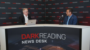  Two people talking at a news desk against a dark backdrop with "Dark Reading" written on it.