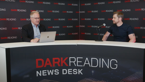 Two people talking at a news desk against a dark backdrop with "Dark Reading" written on it.