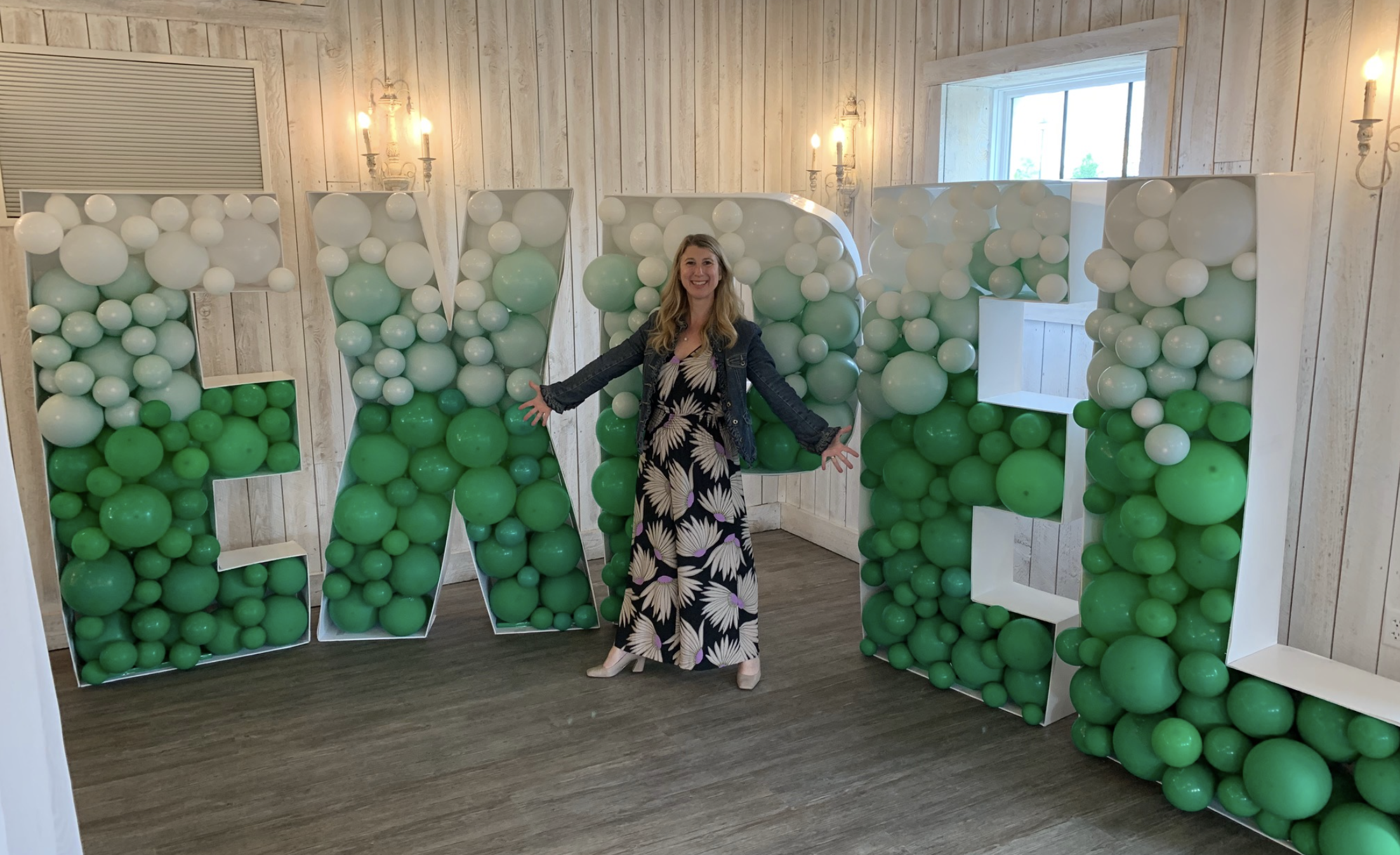 Amy Rossi (Chief People Officer) in front of Expel balloons at company outing