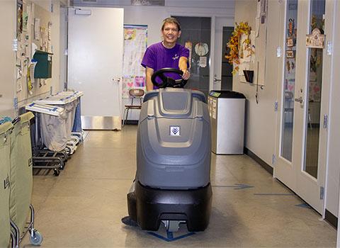 custodian on a riding vacuum