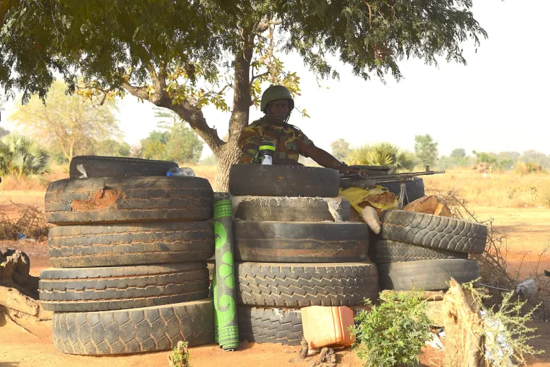 A Togolese soldier holding a machine gun keeps watch near the northern Togo border post with Burkina Faso, on Feb. 17, 2020.