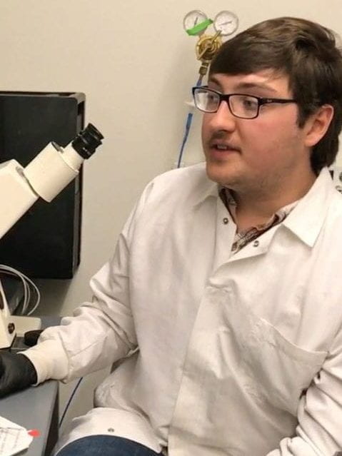 picture of Kristof Tigyi at a microscope