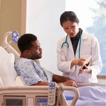 Patient in the hospital with a doctor next to him - Baylor College of Medicine