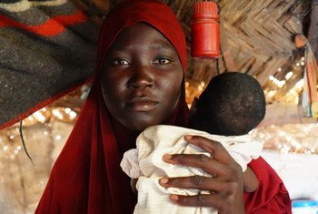 A women hold her baby in a cap for displaced people in Maiduguri in northeastern Nigeria. 