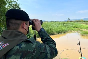 A Thai border officer looks into Myanmar across the frontier between the two countries.