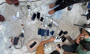 أشخاص عالقون في الصراع في غزة يعيدون شحن هواتفهم المحمولة.
