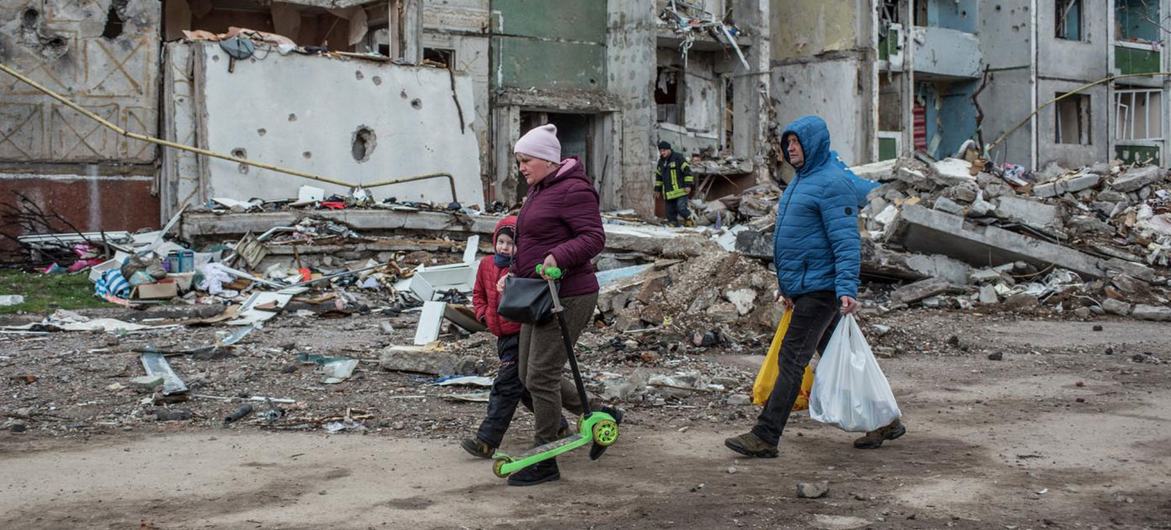 People walk past bomb-damaged building in Chernihiv in northern Ukraine.