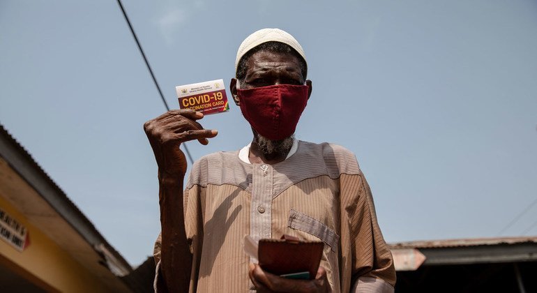 A 76-year-old man shows his vaccination card after receiving a COVID-19 vaccine in Kasoa, Ghana.