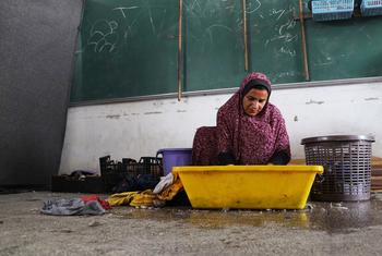A displaced Palestinian woman washes her family's clothes in a classroom at a UNRWA shelter in Khan Younis, southern Gaza.
