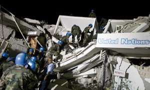 在2010年1月海地大地震发生后，联合国维持和平人员在特派团总部的废墟中寻找生还的同事。