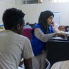 An IOM staff member registers an Ethiopian migrant in Ma’rib, Yemen, prior to travel to Addis Ababa.