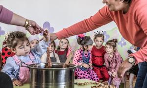 Kindergarten students make chorchella, a traditional Georgian snack of grape paste and walnuts, during an autumn celebration in an IDP settlement in Tsilkani, Georgia.