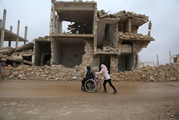 A girl helps her sister on their way home from school in Idlib, North-west Syria.