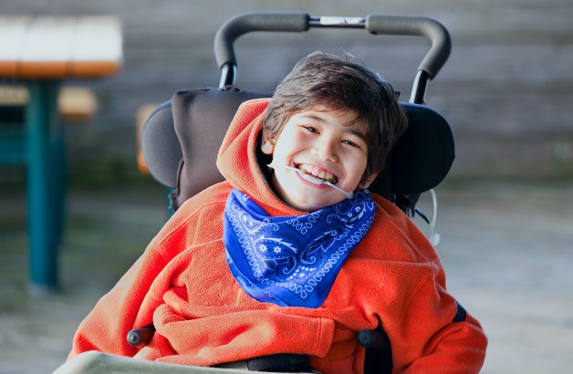 Portrait of a child smiling in a wheelchair