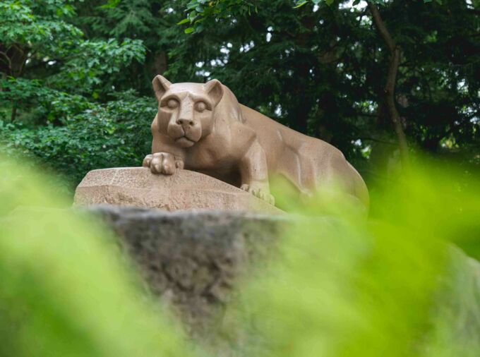 The Nittany Lion Shrine through green leaves