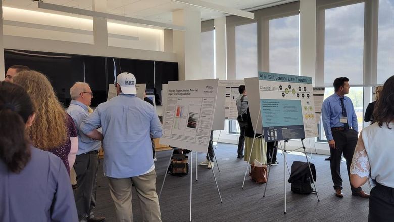 People standing in a room looking at conference posters