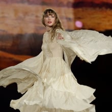 Taylor Swift performing in a gauzy white dress. 