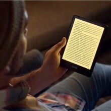 a person reads the kindle paperwhite in a dimly lit room