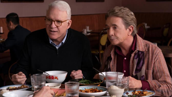 Steve Martin and Martin Short sit next to each other at a table in "Only Murders in the Building."