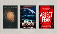 three horror books against a light gray grid